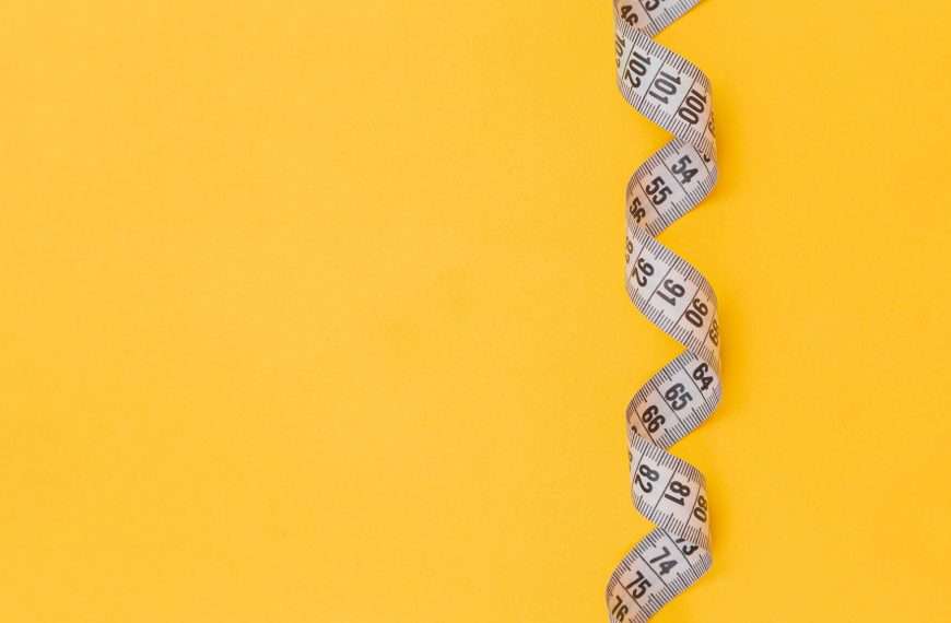 Yellow background with tape measure for body-neutral fitness goals without weight