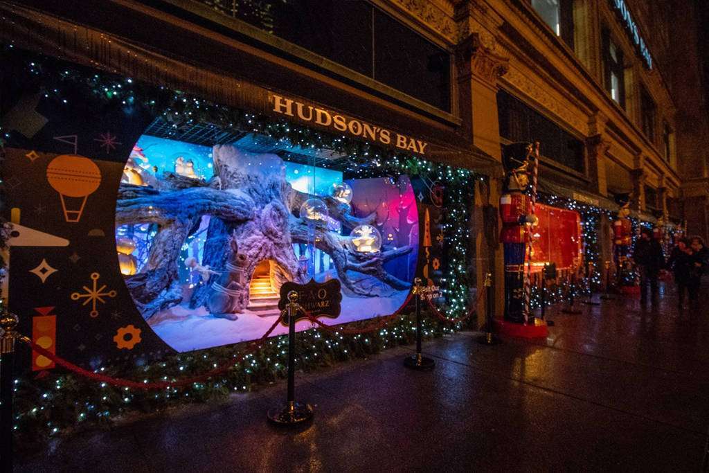Night time image of a Hudson's Bay display window for the holiday season showing a blue-lighted snow forest scene