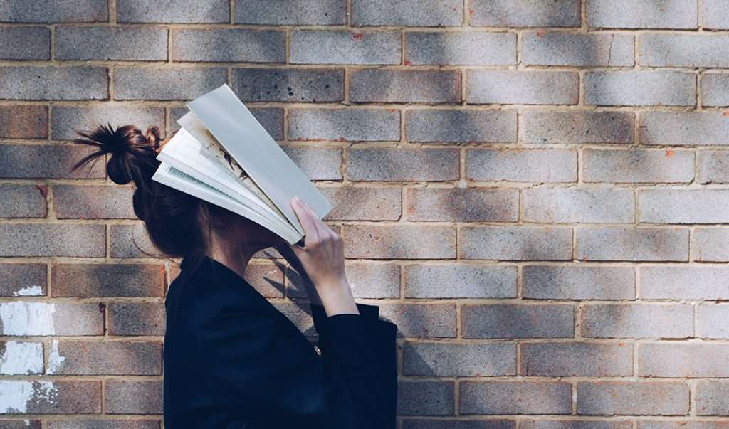 A stressed woman holds papers over her face, a reminder that breathwork alone may not be enough to calm your nervous system.
