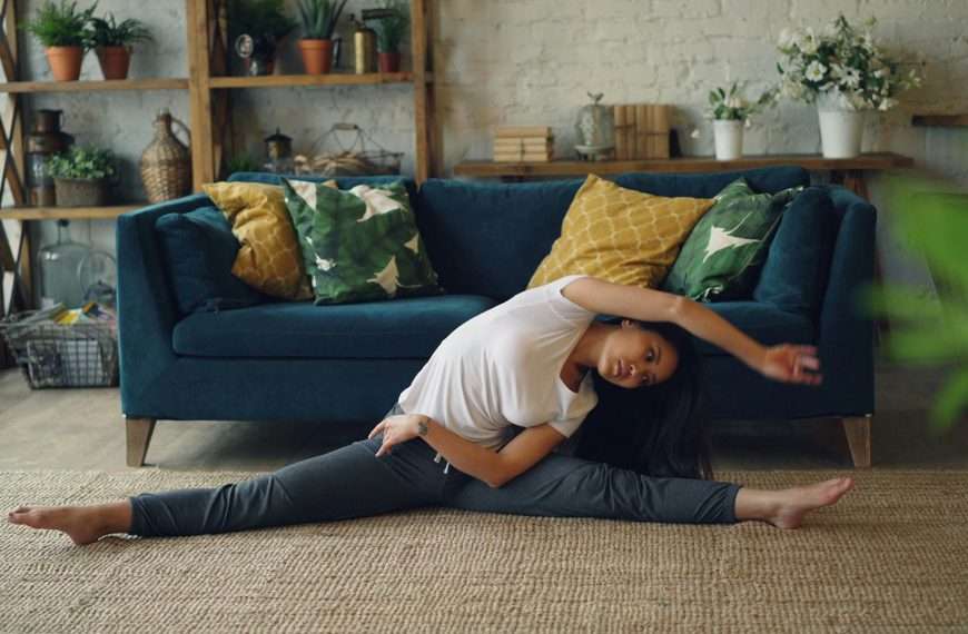 A person practicing a simple hip opener on their living room floor as part of their daily micro goals for flexibility routine.